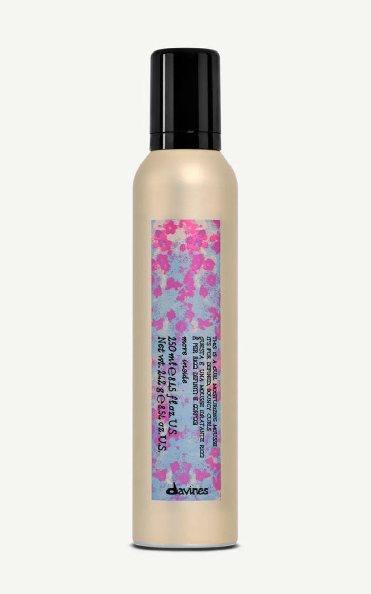 Hair product bottle with floral label on a white background